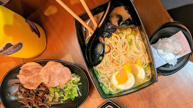 photo of ramen on a table with toppings on the side