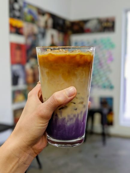 holding an iced coffee with taro fro qreate coffee in orlando