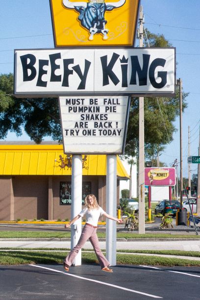 allyson jumping in front of the beefy king sign