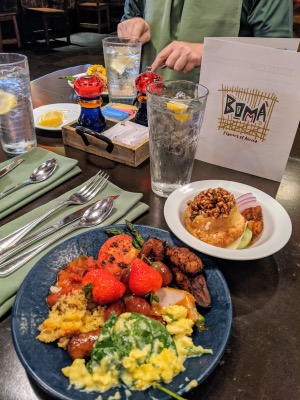 boma buffet at disney, tomatoes, eggs, spinach, and cinnamon roll on a plate together
